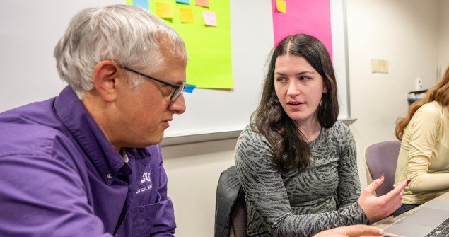 Michael Strausz, professor and chair of the political science department of TCU's AddRan College of Liberal Arts, helps a student.