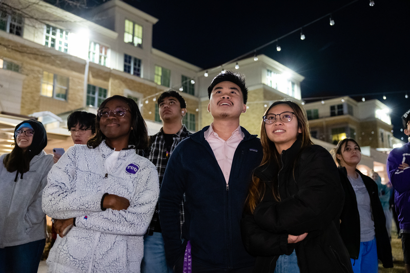 Student standing in a group and looking up 