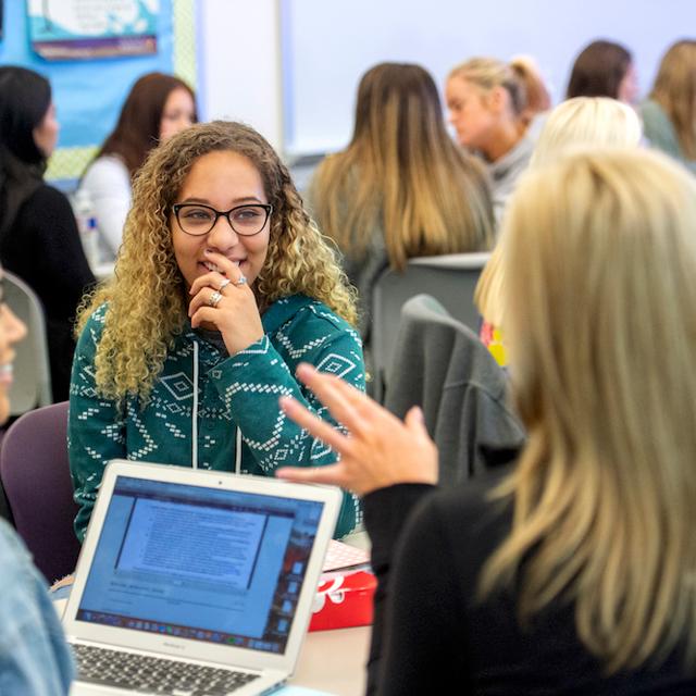 Students laugh while working on a group project