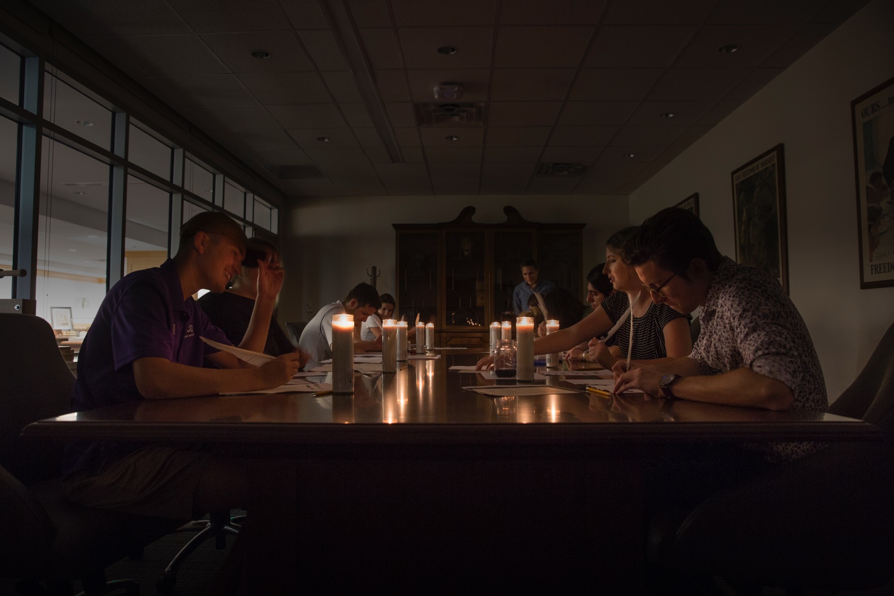 Student write with a quill and ink by candlelight 