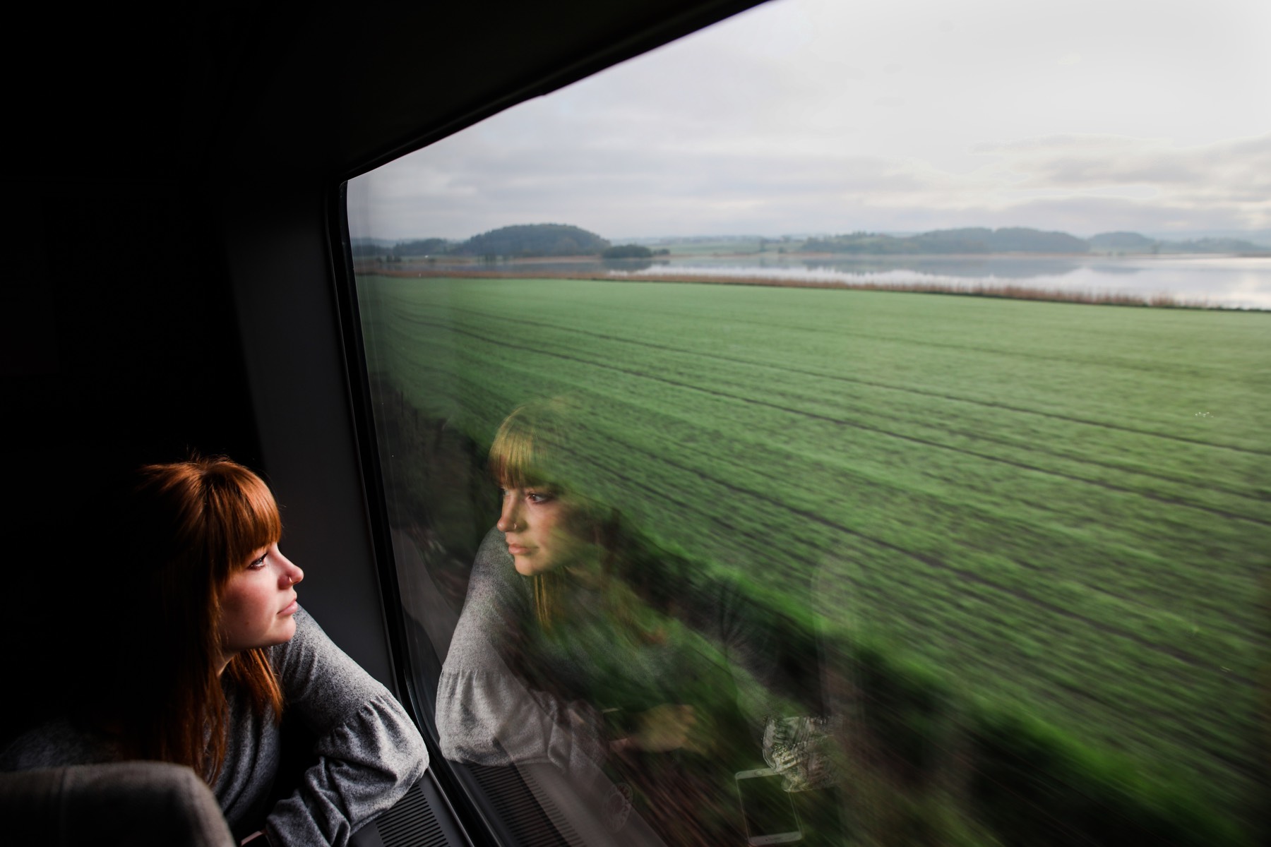 A student looks out a train window