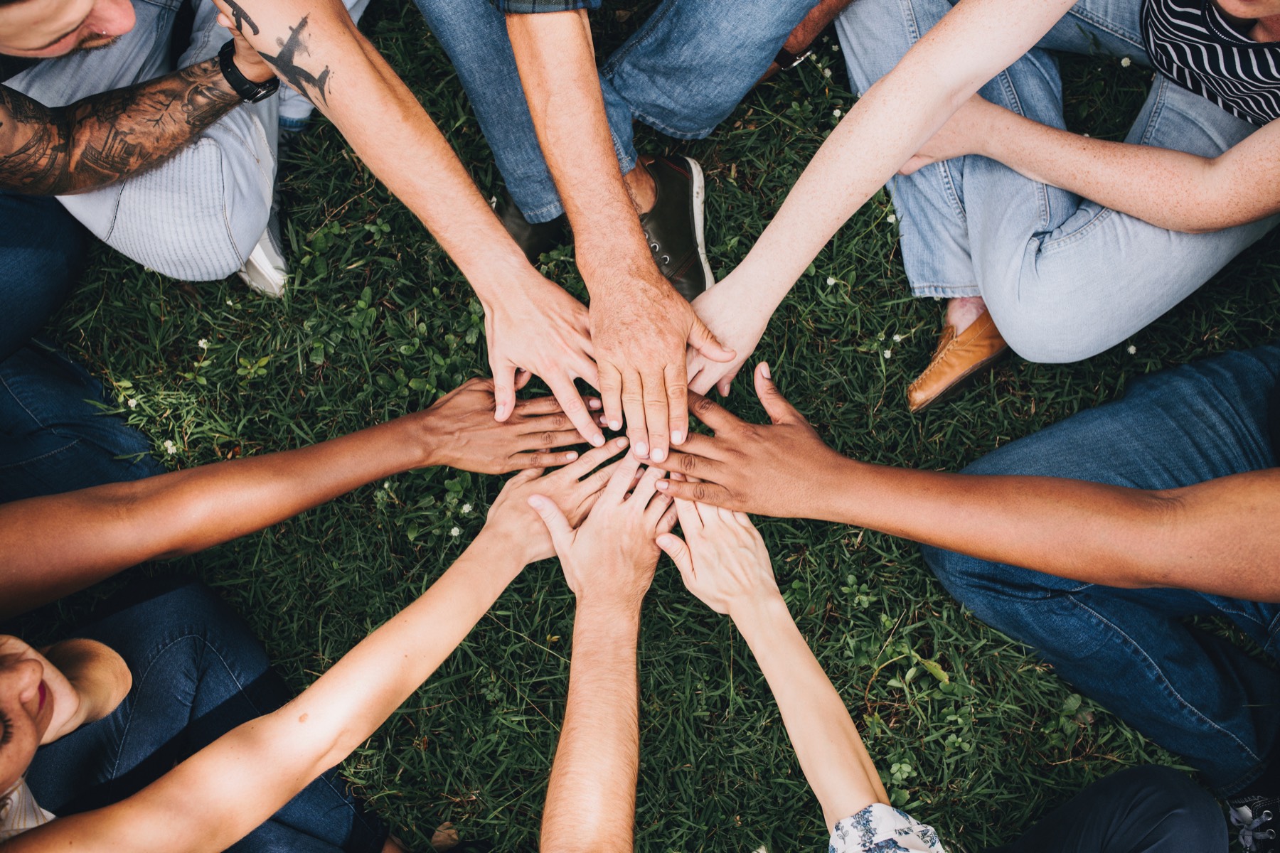 Students put their hands together in a circle