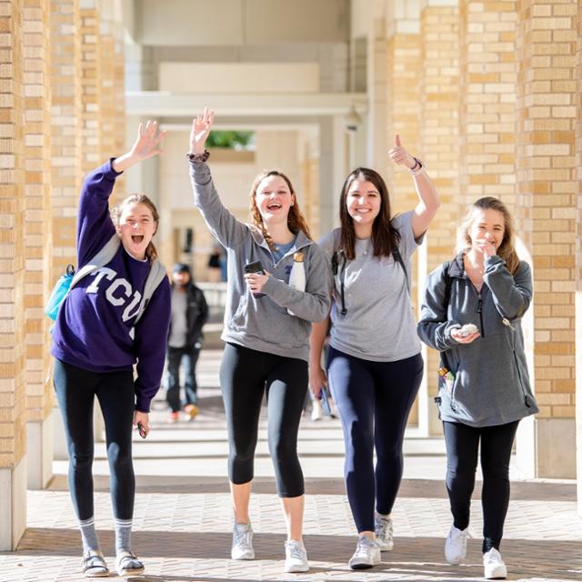 Students smile and wave at the camera