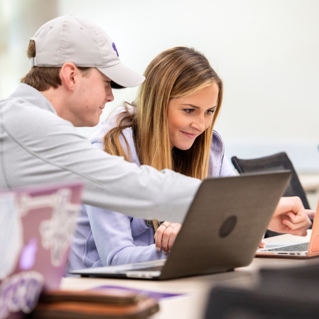 Students looking at laptops. 