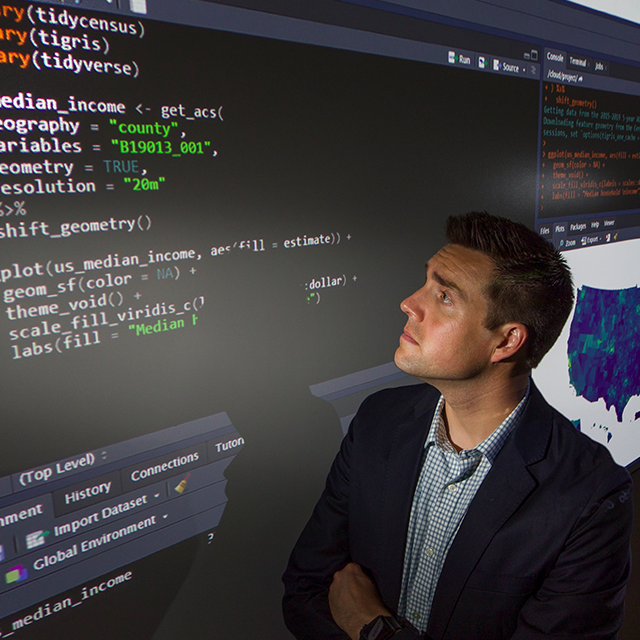 Kyle Walker, Ph.D., reviews computer code in the TCU Center for Urban Studies