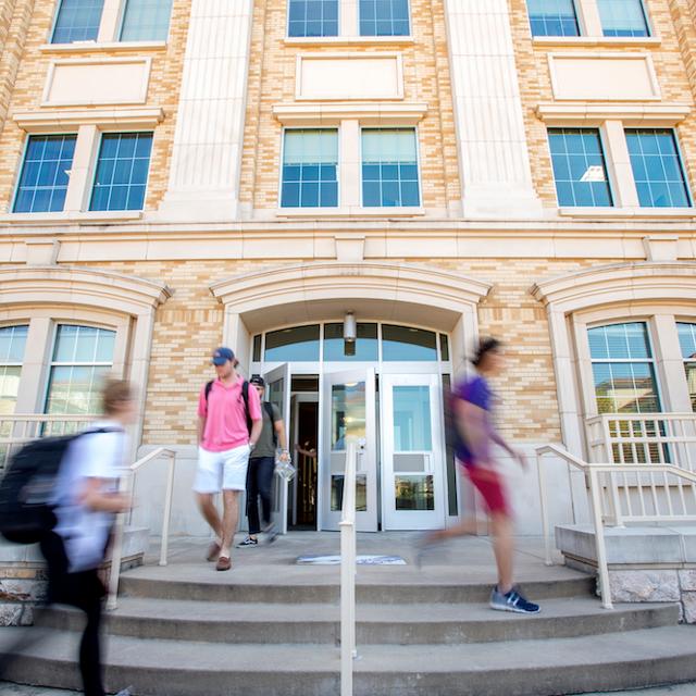 Students walk out of a building