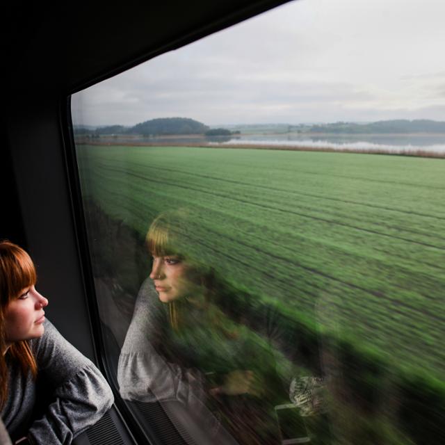 A girl looks out a train window