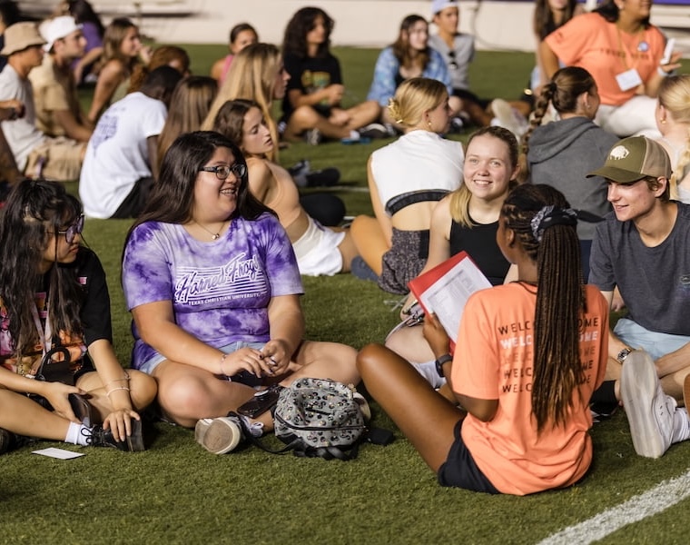 Students sitting in a group on a field