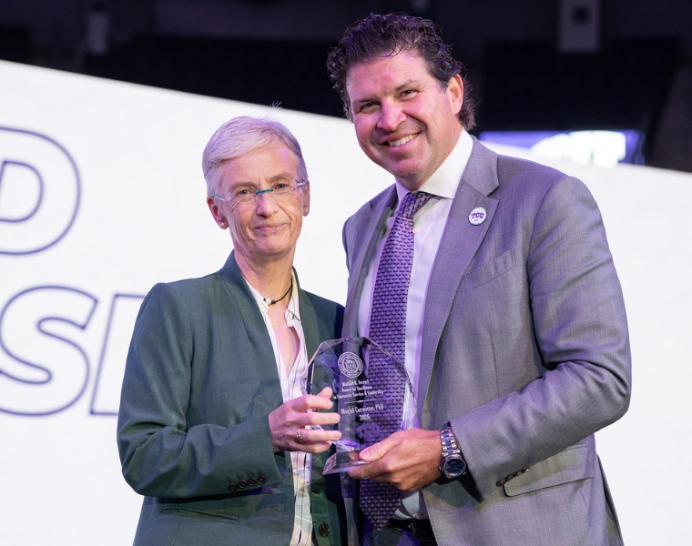 Muriel Cormican and Daniel Pullin smiling and holding an award.